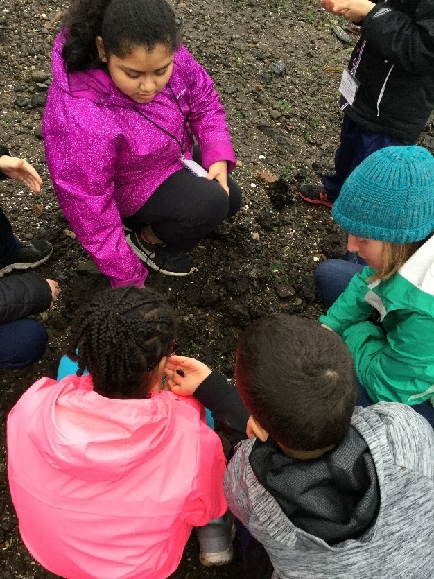 Graduate student Julia Glassy investigates the soil with School Overnight Program students.