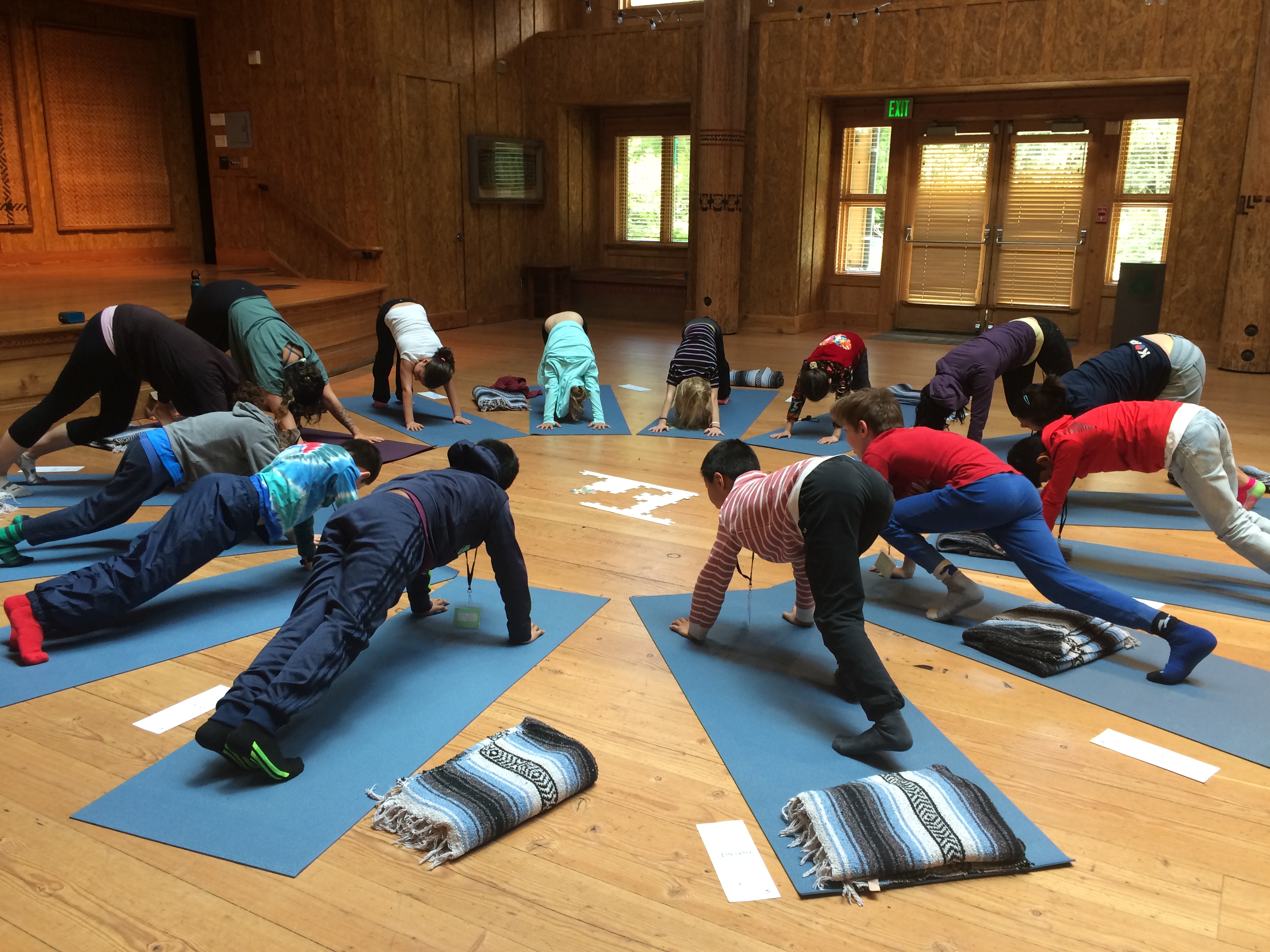 School Overnight Program students doing yoga in the Great Hall on IslandWood's Bainbridge Island campus.