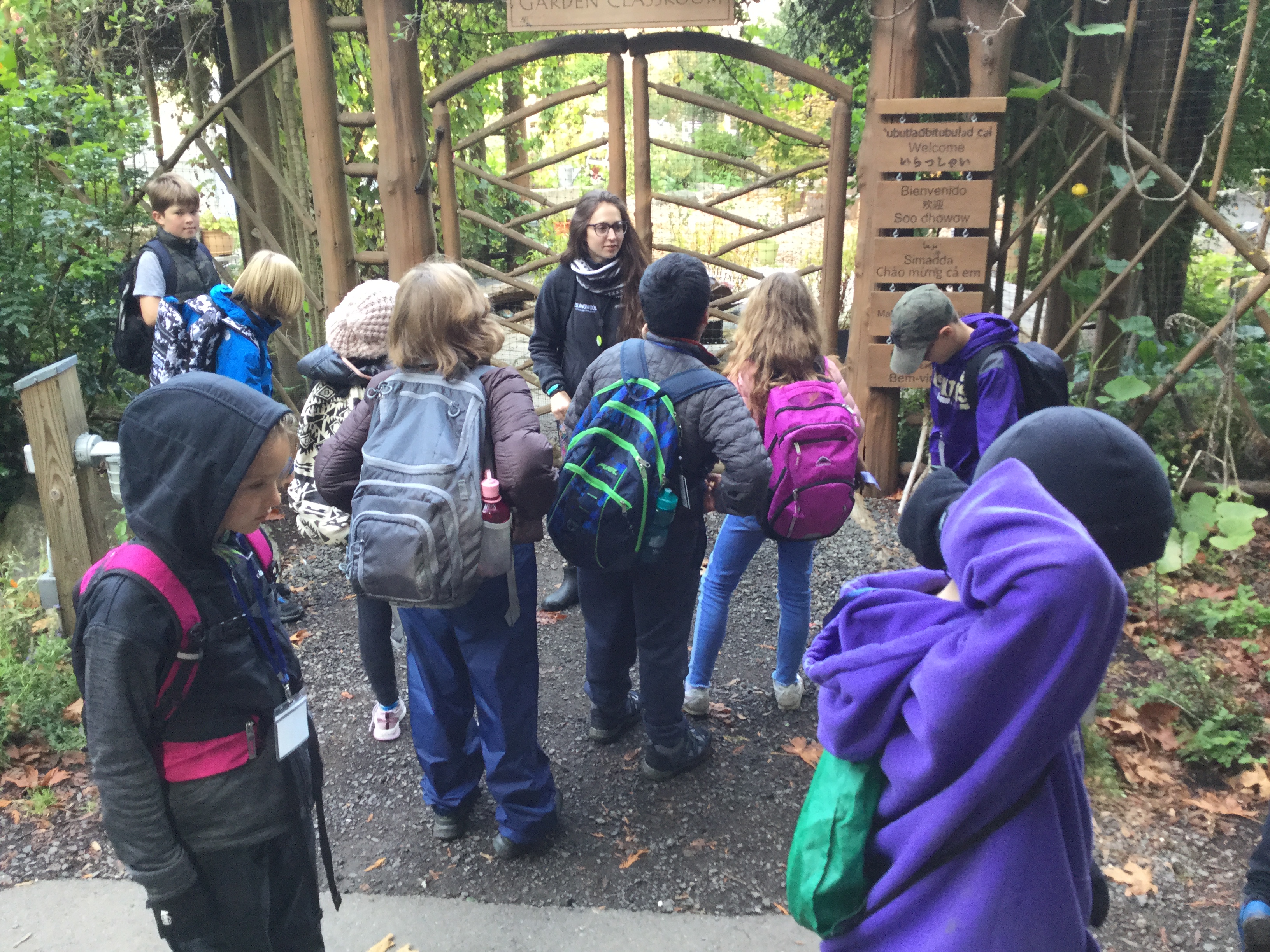 Kyleen stands outside of the IslandWood garden with a group pf School Overnight Program students.