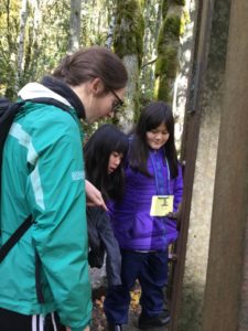 Kyleen in the forest with two students from the School Overnight Program.